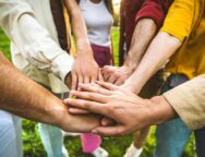 Group,Of,People,Stacking,Hands,Together,-,Team,Building,Celebrating
