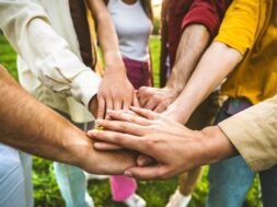 Group,Of,People,Stacking,Hands,Together,-,Team,Building,Celebrating